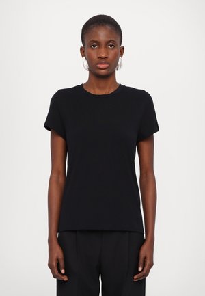 Black, short-sleeve t-shirt made of soft fabric with a crew neckline and relaxed fit. Paired with dark, formal trousers.