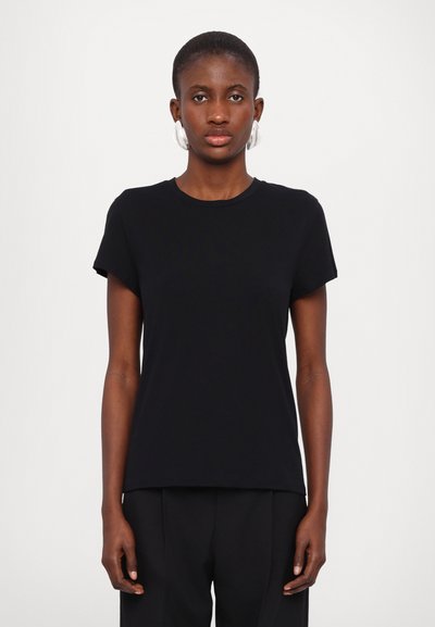 T-shirt noire à manches courtes en tissu doux, avec un col rond et une coupe décontractée. Associé à un pantalon formel foncé.