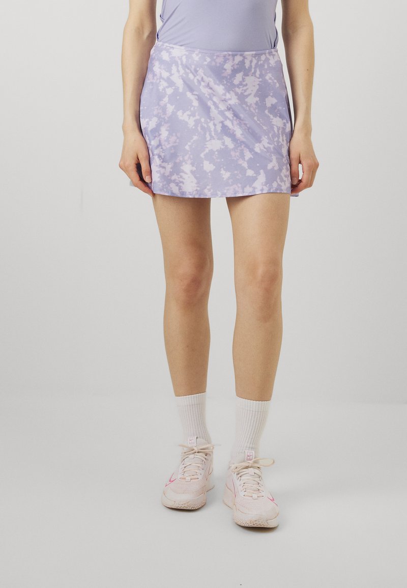 Purple tie-dye skirt made of soft, lightweight fabric, featuring a flared design and a smooth texture, paired with white athletic socks and shoes.