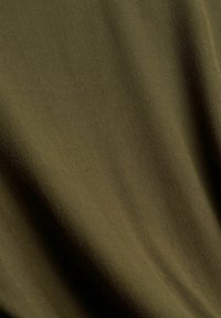 Tessuto verde oliva con una superficie liscia e una leggera lucentezza, che presenta una leggera elasticità e un delicato motivo fine in tutto il tessuto.