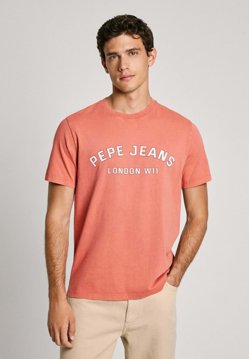 Ružovo-oranžové bavlnené tričko s okrúhlym výstrihom a krátkymi rukávmi. Na prednej strane je vyvedený text "PEPE JEANS LONDON W11" v bielej farbe.