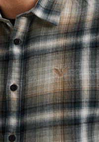 Camisa de cuadros en tonos de azul, beige y blanco; cuenta con un sutil logo bordado; hecha de un tejido texturizado con un corte clásico.