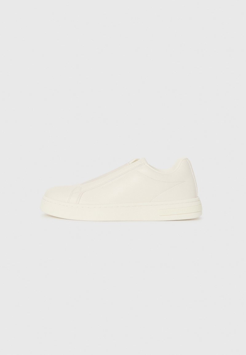 Küljedeta beez nahast madalate sneakeritega, ümar varvas, minimaalne õmblus ja külglahtisus valgel taustal.