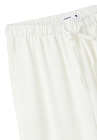 Pantaloni bianchi con vita elastica e chiusura con cordino. Tessuto morbido, vestibilità comoda, texture liscia, design minimalista senza motivi o dettagli.
