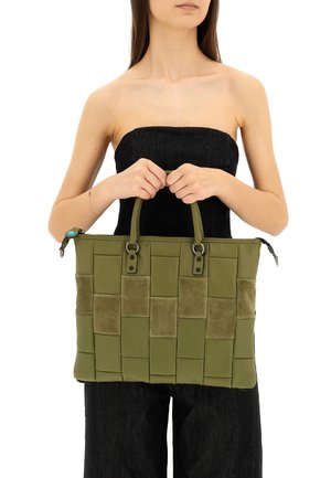 Borsa tote verde oliva con texture intrecciata e accenti in suede, caratterizzata da doppi manici e chiusura con zip. Materiale in pelle liscia in tutto.