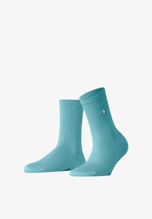 Een paar geribbelde sokken tot over de enkel in licht teal met een klein rond logo aan de zijkant en zwarte tekst bij de tenen.