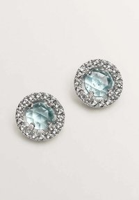 Pendientes redondos con piedras preciosas facetadas de color azul claro en el centro, rodeadas de strass transparentes en un marco de tono plateado.