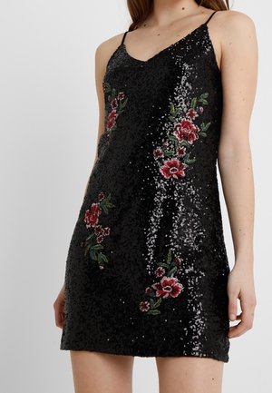 Black sequin mini dress with thin straps and red floral embroidery worn by a person from shoulders to mid-thigh.
