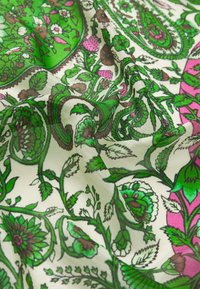Colorful floral silk fabric features a green and pink paisley design with intricate leaves and flowers on a light background.