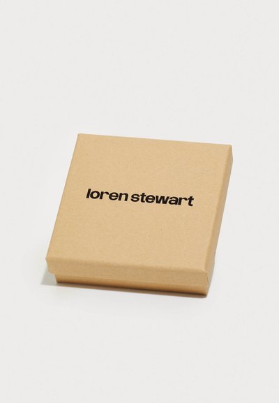 Smeđi kartonski poklon box s glatkom teksturom, na vrhu s ispisanim imenom brenda "loren stewart" u debelim crnim slovima.