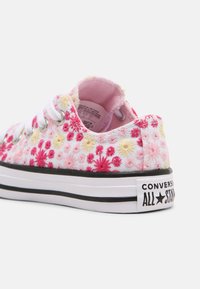 Růžové plátěné tenisky s květinovou výšivkou v růžové a žluté barvě, bílé tkaničky, černá gumová podrážka a branding "Converse All Star".