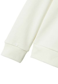 Manga de sudadera blanca con puño acanalado; textura suave y tejido liso; ligero brillo; diseño limpio y minimalista.