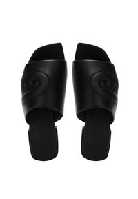 Black slide sandals featuring a wide, glossy leather strap with subtle embossed detailing and a flat rubber sole.
