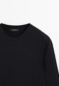 Navyblaues Strickpullover mit gerippter Textur, rundem Ausschnitt und dem Etikett "Massimo Dutti". Die Verarbeitung weist auf Qualität und Design hin.