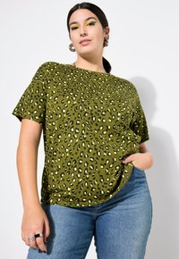 Grünes Leopardenmuster-T-Shirt mit kurzen Ärmeln, einem runden Ausschnitt und einer lockeren Passform. Hergestellt aus weichem, glattem Baumwollmaterial.
