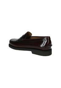 Scarpa penny loafer in pelle marrone scuro con suola nera, cuciture visibili e design slip-on, vista da un angolo laterale.