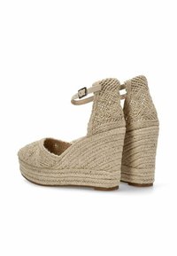 Sandalias de cuña trenzadas en color beige con tira para el tobillo, que presentan patrones intrincados y tela texturizada, punta redonda y una plataforma de yute estratificada.