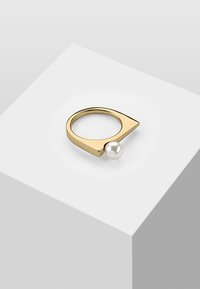 Anello in metallo dorato con bordo arrotondato e un accento di perla bianca sferica. Superficie liscia con un design angolare contemporaneo.