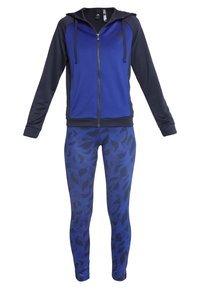 Sweat à capuche zippé bleu et noir avec cordons, associé à un legging bleu arborant un motif de feuilles abstraites foncées.