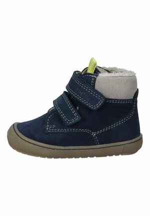 Marineblaue Leder-Stiefelette mit beigen Akzenten, Klettverschlüssen und einer strukturierten Gummisohle. Mit genähten Details und einem weichen Futter.