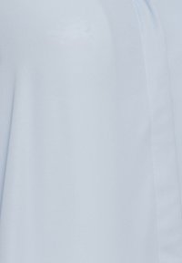 Drappeggio in tessuto blu chiaro con una texture liscia. Presenta una leggera lucentezza e una prominente cucitura bianca lungo la cucitura. Design minimalista.