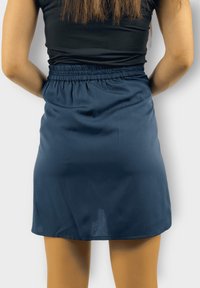 Falda azul marino con cintura elástica, hecha de una tela suave, con corte recto y detalles sutiles en el dobladillo.