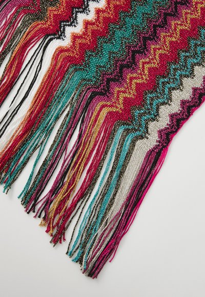 Bufanda tejida multicolor con un patrón en zigzag en tonos vibrantes, con detalles de flecos brillantes en colores variados de rojo, verde azulado y dorado.