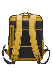 Zaino giallo e nero realizzato in pelle e materiali a rete, dotato di spallacci regolabili, una maniglia superiore e numerose tasche esterne.