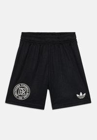 Svarta idrottsshorts med ribbad textur, med en vit cirkulär logotyp och en vit Adidas treklöksdetalj på nedre högra sidan.