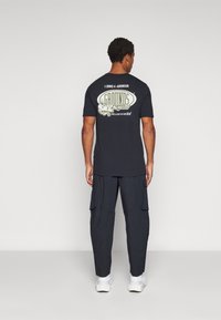 Under Armour UNSTOPPABLE - Hlače za otvoreno - black