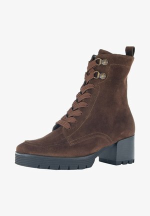 Brown suede ankle boot with a round toe, lace-up front, metal accents, and a chunky black heel. Textured surface and rugged sole.