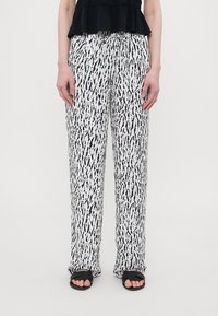 Loose-fitting trousers with a black and white abstract pattern, made of lightweight fabric. Features an elastic waistband and side pockets.