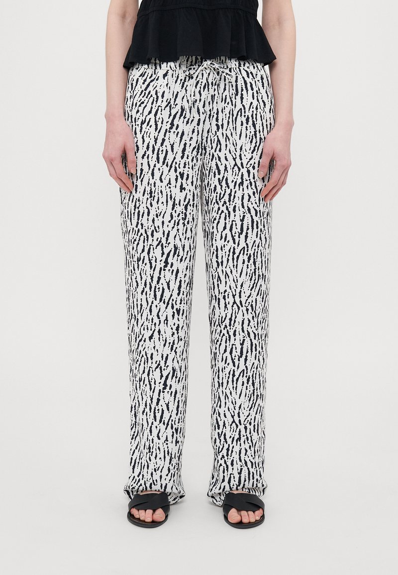 Loose-fitting trousers with a black and white abstract pattern, made of lightweight fabric. Features an elastic waistband and side pockets.
