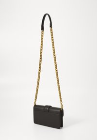Black rectangular leather crossbody bag with gold chain strap and black shoulder pad, shown hanging against white background.