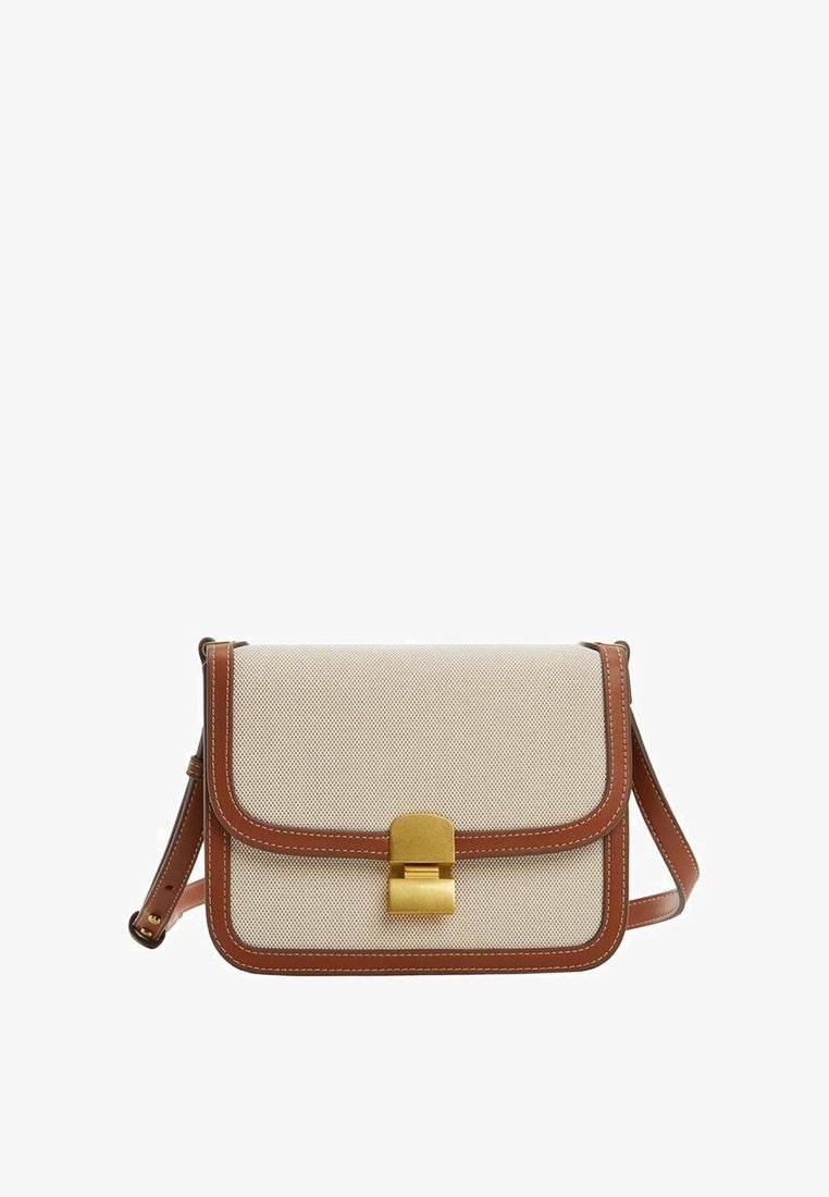 Sac bandoulière en tissu beige avec garniture en cuir marron et sangle ajustable, doté d'une fermeture à boucle rectangulaire en métal doré.