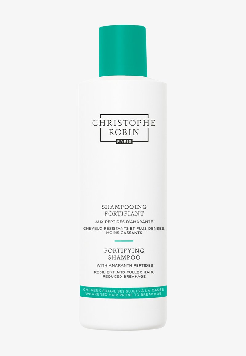 Bouteille de shampooing cylindrique blanche avec un capuchon turquoise. L'étiquette présente un texte noir pour le nom du produit et sa description, avec un design minimaliste.