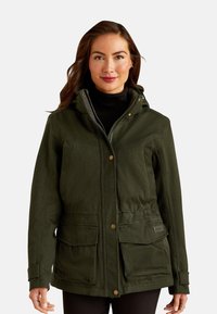 Groene jas met een gestructureerde afwerking, voorkantzakken, knoopsluiting, een hoge kraag en een capuchon. Draagt over een zwarte top.