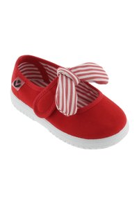Zapato rojo para niños con suela de goma blanca, lazo de tela a rayas rosas y blancas y forro interior a juego con rayas.