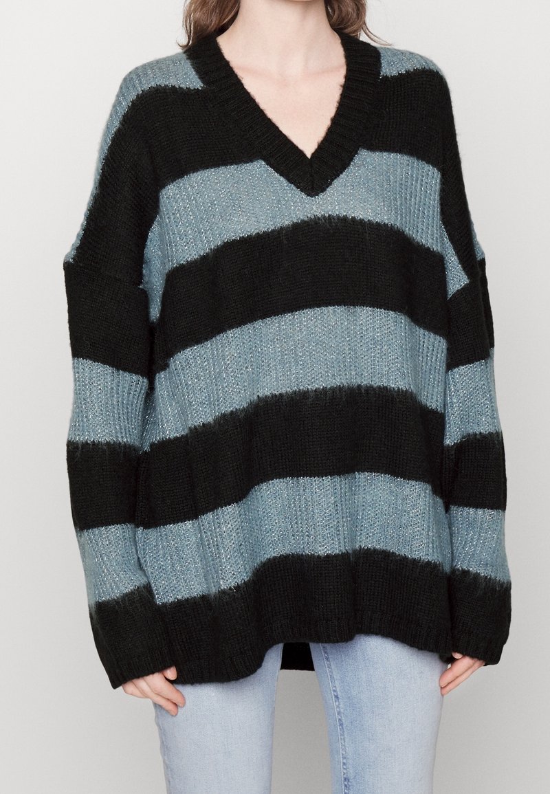 Oversized sweater with a V-neck, featuring wide black and light blue horizontal stripes. Made of textured knit fabric with ribbed hems.