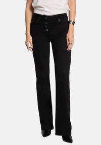 Jeans negros acampanados de mezclilla, con cinco botones en la parte frontal, bolsillos delanteros y cintura ajustada. Textura suave sin patrones visibles.