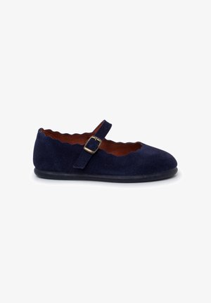 Navy blue suede Mary Jane shoe with scalloped edges, adjustable strap, and a rounded toe design. Brown leather insole and black rubber sole.