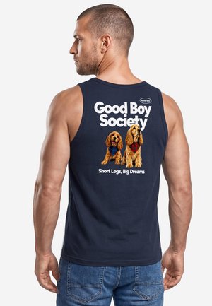 Man wearing navy tank top with text "Good Boy Society" and image of two dogs wearing scarves on the back.