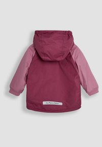 Vinröd och pink hooded jacka med pinka ärmar. Har elastiska manschetter och ett märke vid fållen. Slitstarkt, mjukt tyg, designat för värme.