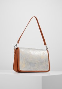 Karmelowa skórzana torba na ramię z metaliczną klapą w kolorze srebrnym, zdobioną złotymi kwiatowymi wzorami, regulowanym paskiem oraz srebrnymi elementami metalowymi.