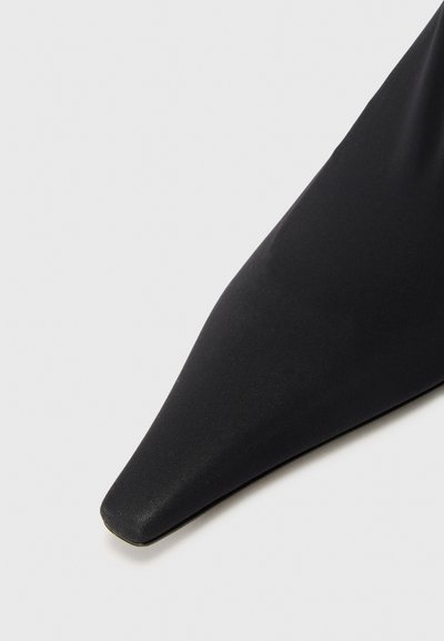 Crne cipele s oštrim nosom napravljene od glatkoga sintetičkog materijala, s elegantnim dizajnom i suptilnim sjajem na površini.