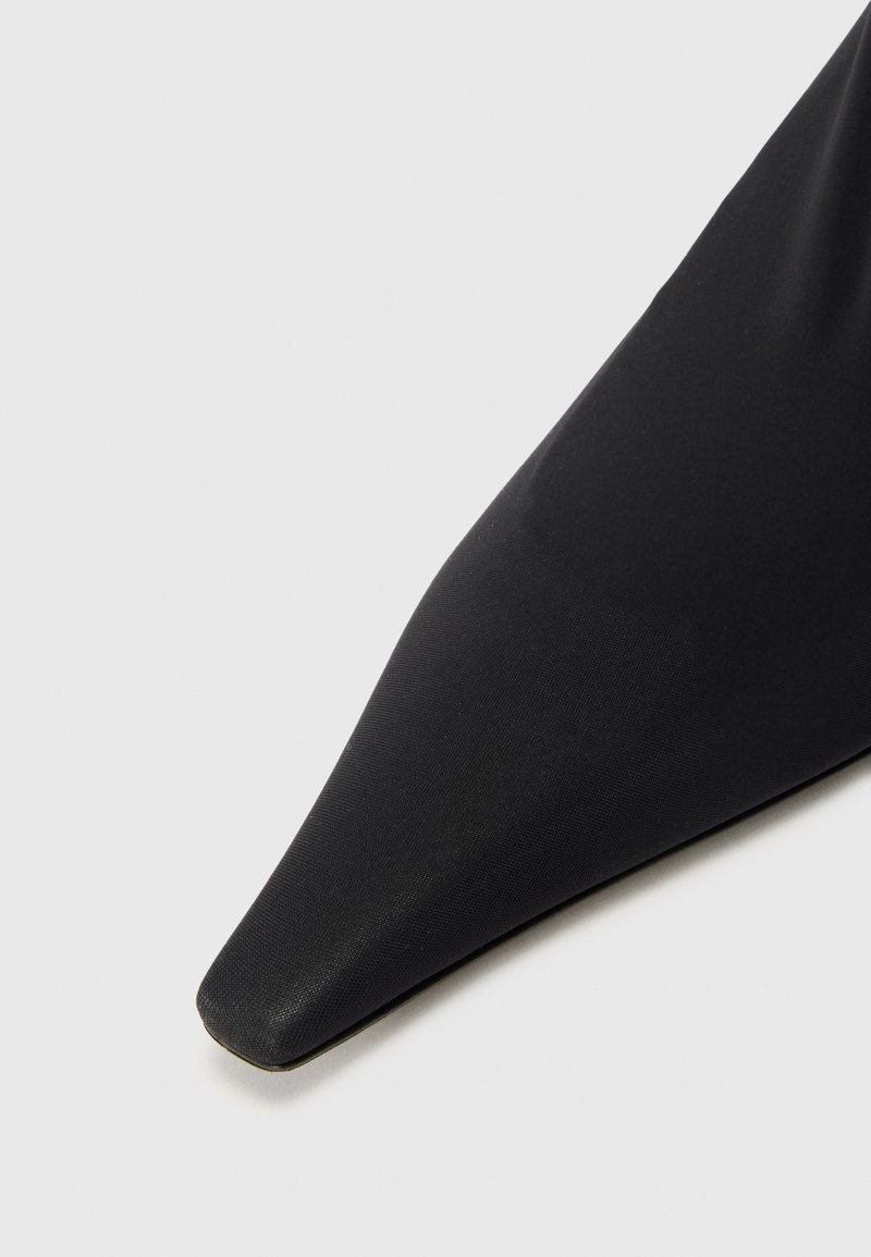 Sorte spidse pumps lavet af glat syntetisk materiale, med et elegant design og en subtil glans på overfladen.