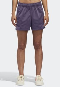 Purple athletic shorts with an elastic waistband, made from lightweight material. Features white stripes along the sides.
