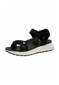 Černé sandály s širokými popruhy a suchým zipem, s polstrovanou černou stélkou a bílou polstrovanou podrážkou s texturovaným vzorem.