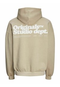 Krémová mikina s kapucí na stažení, oversized střih a bílý grafický text na zadní straně, obsahující "Originals Studio dept." a detaily loga.