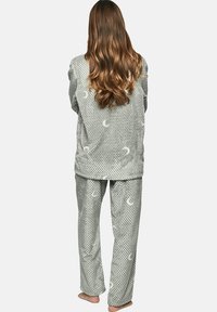 Ensemble de pyjama gris en tissu texturé avec des motifs de croissants de lune. Comprend un haut à manches longues et un pantalon assorti. Design doux et confortable.